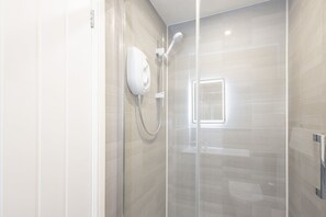 Een douche, handdoeken, zeep, shampoo