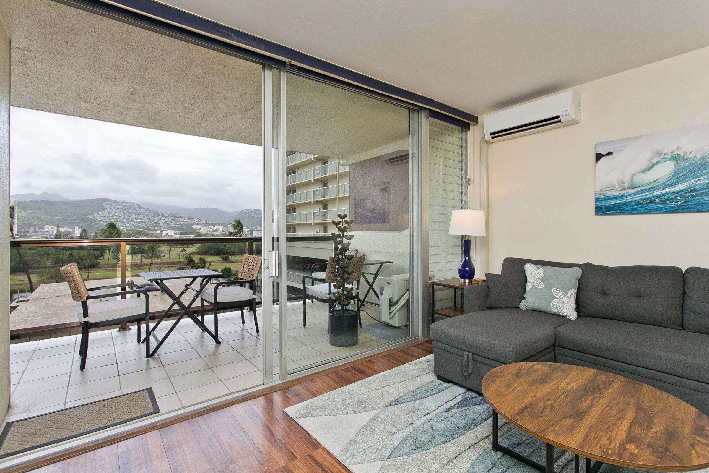 Un salón con sofá, mesa de centro y vistas a un balcón con comedor.