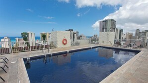 A rooftop pool with a clear view of the city skyline and the ocean.