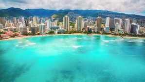 A coastal cityscape with high-rise buildings and a turquoise beach. - Mellow Kuhio Village Studio | Private Lanai (Honolulu)