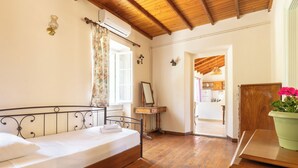 Une chambre à coucher avec un lit en bois, une petite table de chevet, un miroir et une plante en pot.