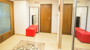 Ein modernes Interieur mit einer Holztür, einer roten Bank und einem gemusterten Boden.