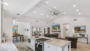 A spacious kitchen with a central island, an oven, and a dining area with a table and chairs.