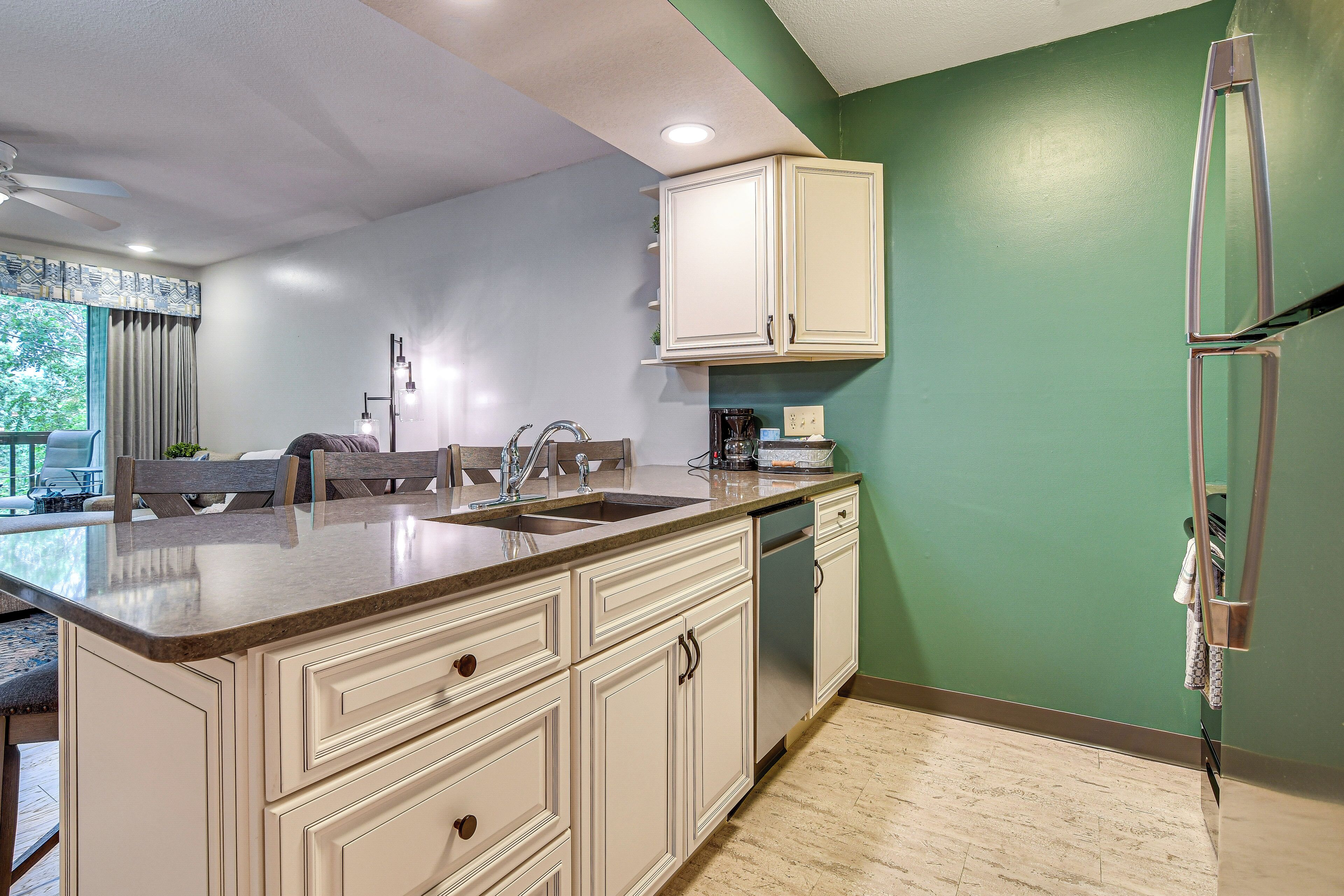 A kitchen with a large island, a dishwasher, and a refrigerator.