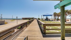 A wooden boardwalk leading to a beach area with a gazebo and palm trees. - Walk to Pier: St Augustine Beach Condo w/ Balcony! (St. Augustine)