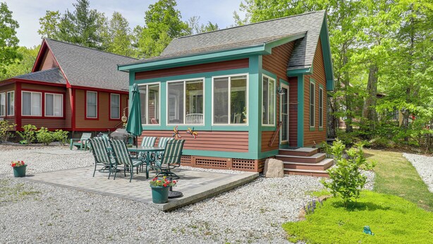 A house with a covered patio area, outdoor seating, and a small garden. - Summer Village Family Cottage w/ Community Perks! (Westford)