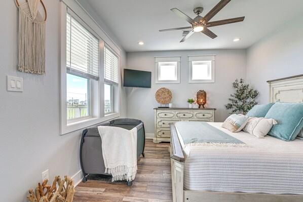 A bedroom with a bed, a ceiling fan, a dresser, and a window. - Winter Getaway: Near Sea Isle Beach & Parks (Galveston)