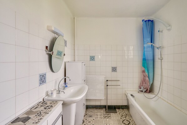 Ein Badezimmer mit Waschbecken, Spiegel und Badewanne.