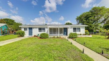Stylish single-story home with a charming front porch and well-manicured lawn.