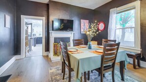 A dining area with a table set for four, a fireplace, and a television on the wall. - Walk to U of Lynchburg: Big Home w/ Yard & Hot Tub (Lynchburg)