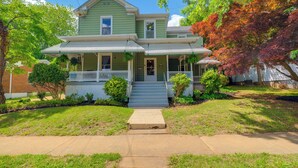 A two-story house with a front porch, a small front yard, and a driveway leading to the entrance. - Walk to U of Lynchburg: Big Home w/ Yard & Hot Tub (Lynchburg)