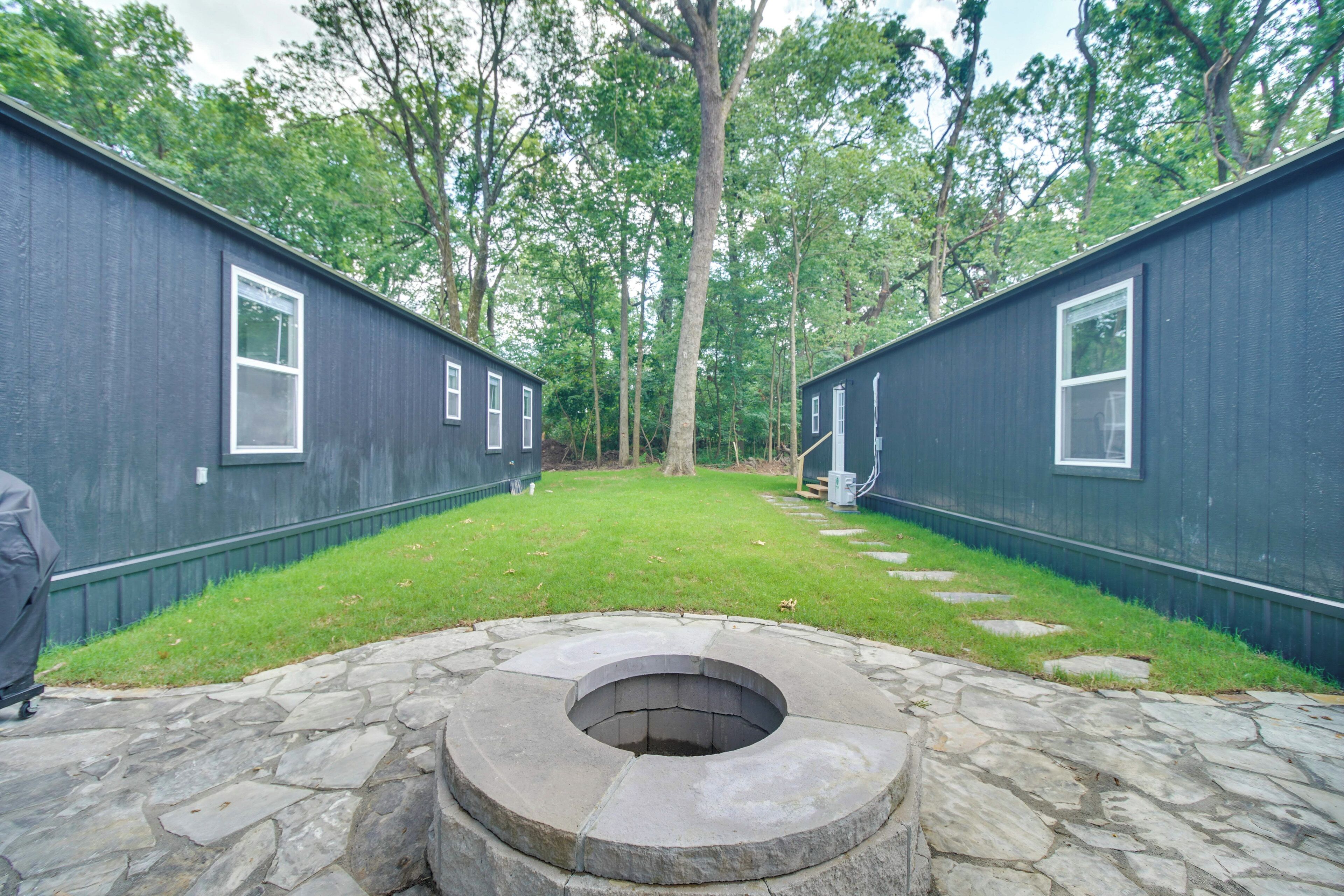 A row of cabins with a stone fire pit in the center.