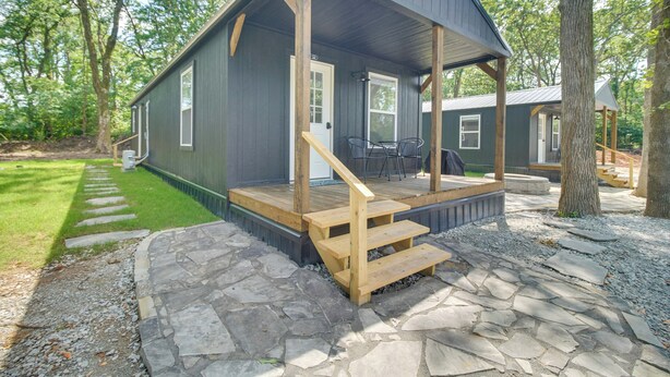 A cabin with a wooden deck, stone pathway, and a covered porch. - Walk to Lake: Cozy Grove Cabin w/ Fire Pit (Grove)