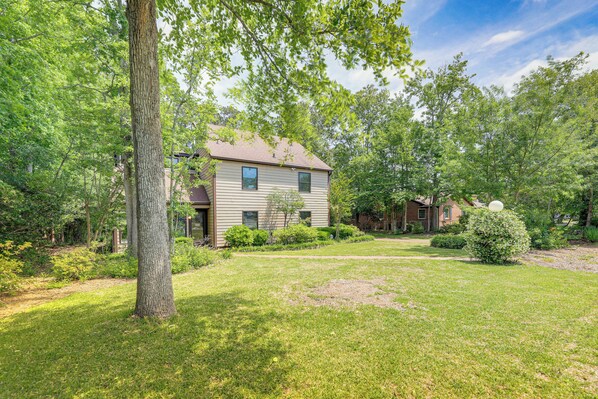 A two-story house with a well-maintained lawn and mature trees.