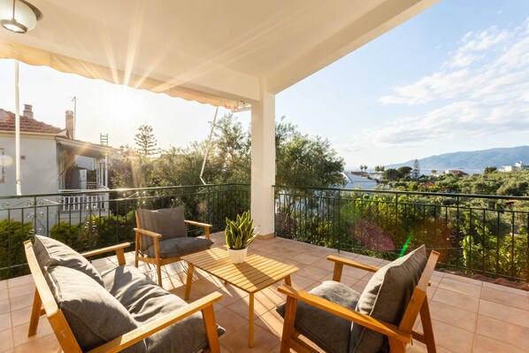 A balcony with wooden furniture, a table, and a potted plant.