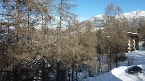 A snow-covered landscape with a building that appears to be a lodge or cabin, surrounded by trees and mountains in the background. - 3rd floor, balcony, 40m², Les Orres (Les Orres)