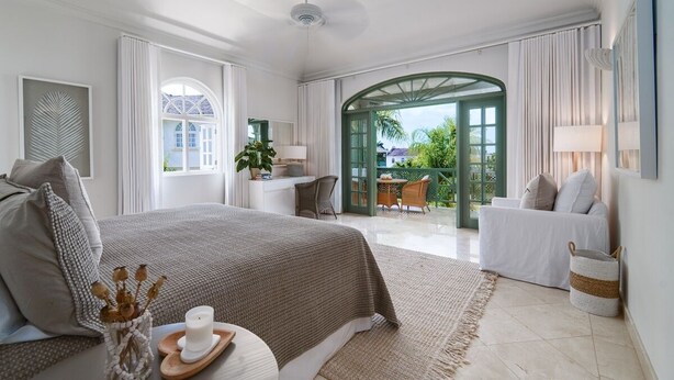 Une chambre spacieuse avec un grand lit, un coin salon avec un canapé et une vue sur l’extérieur.
