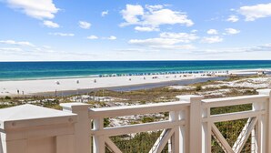 A beach view with a clear sky, sandy beach, and a wooden fence. - Retreat Steps from Sugar-White Sand (Watersound)