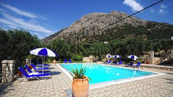 Una piscina al aire libre de temporada, sombrillas