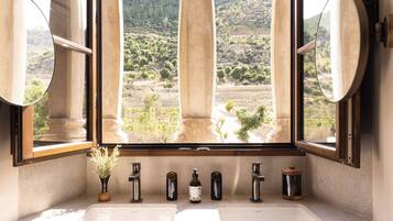 Un baño con una ventana grande, un lavamanos y un espejo.