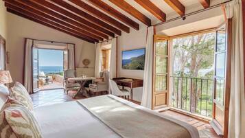 Quarto com uma cama grande, escrivaninha e vista para o exterior.