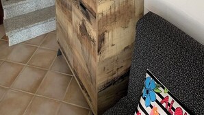 Huoneessa on puinen kaappi, portaikko ja seinälle asennettu ilmastointilaite.