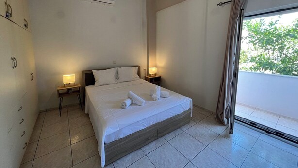 Habitación de hotel con cama, lámparas de noche, aire acondicionado y vistas por la ventana.