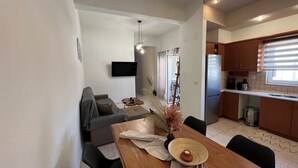Un espacio de estar moderno con comedor, cocina y zona de descanso.