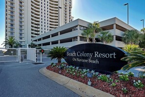 Schild für Beach Colony Resort mit Parkhaus im Hintergrund.