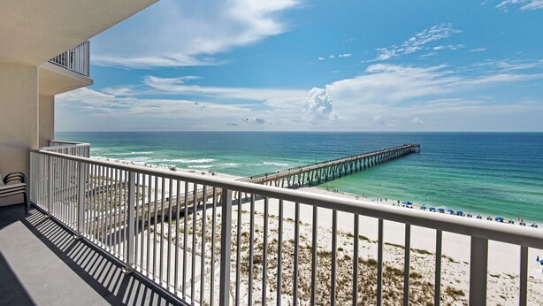 A balcony with a view of a beach and a pier extending into the ocean. - Captain`s Hideaway - Summerwind 905E (Navarre)