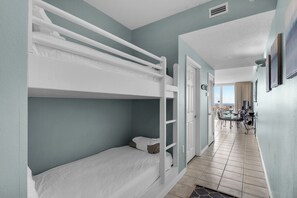Habitación de hotel con literas, zona de comedor con vistas y kitchenette.