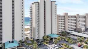 Un grand hôtel à plusieurs étages, doté d’un parking et offrant une vue sur la plage.