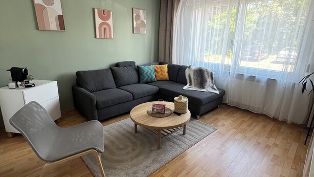 A modern living room with a grey sofa, a wooden coffee table, and a grey armchair. - TOP Anbindung + Nähe Hannover + 2min Lehrte BHF (Lehrte)