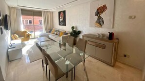 Una sala moderna con una mesa de comedor de cristal, sofás y un aparador.