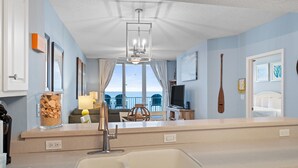 A modern kitchen with a large window, a built-in sink, and a dining area visible through the window. - Slow M'Ocean - Summerwind 1302C (Navarre)