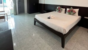 Ein Hotelzimmer mit einem großen Bett, einem Schreibtisch und Blick auf die Stadt.