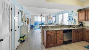 A modern kitchen with wooden cabinets, a granite countertop, and a dishwasher.