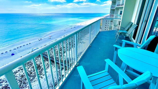 A balcony with a view of a beach and ocean.