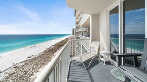 A balcony with a view of a beach and ocean.