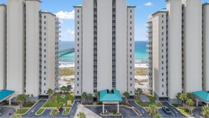 Un hôtel de grande hauteur, avec de nombreux étages, une cour intérieure et une vue sur la plage et l’océan.