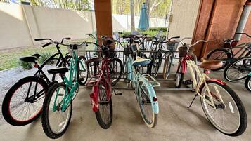Un área de estacionamiento techada para bicicletas, con varias bicicletas y suelo de hormigón.