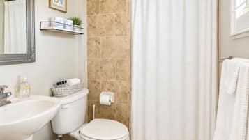 A bathroom with a sink, toilet, and shower curtain.