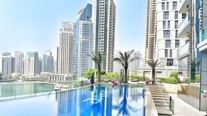 Una piscina infinita moderna con el horizonte de una ciudad al fondo.