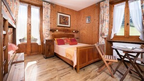 A wooden room with a bed, a desk, and a chair. - 300m from ski slopes, 1st floor, parking, tv, 46m², Arêches-Beaufort (Beaufort)