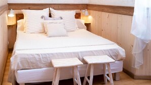 A bedroom with a wooden bed, two bedside tables, a hanging light fixture, and a wooden floor. - 300m from ski slopes, 1st floor, parking, tv, 46m², Arêches-Beaufort (Beaufort)