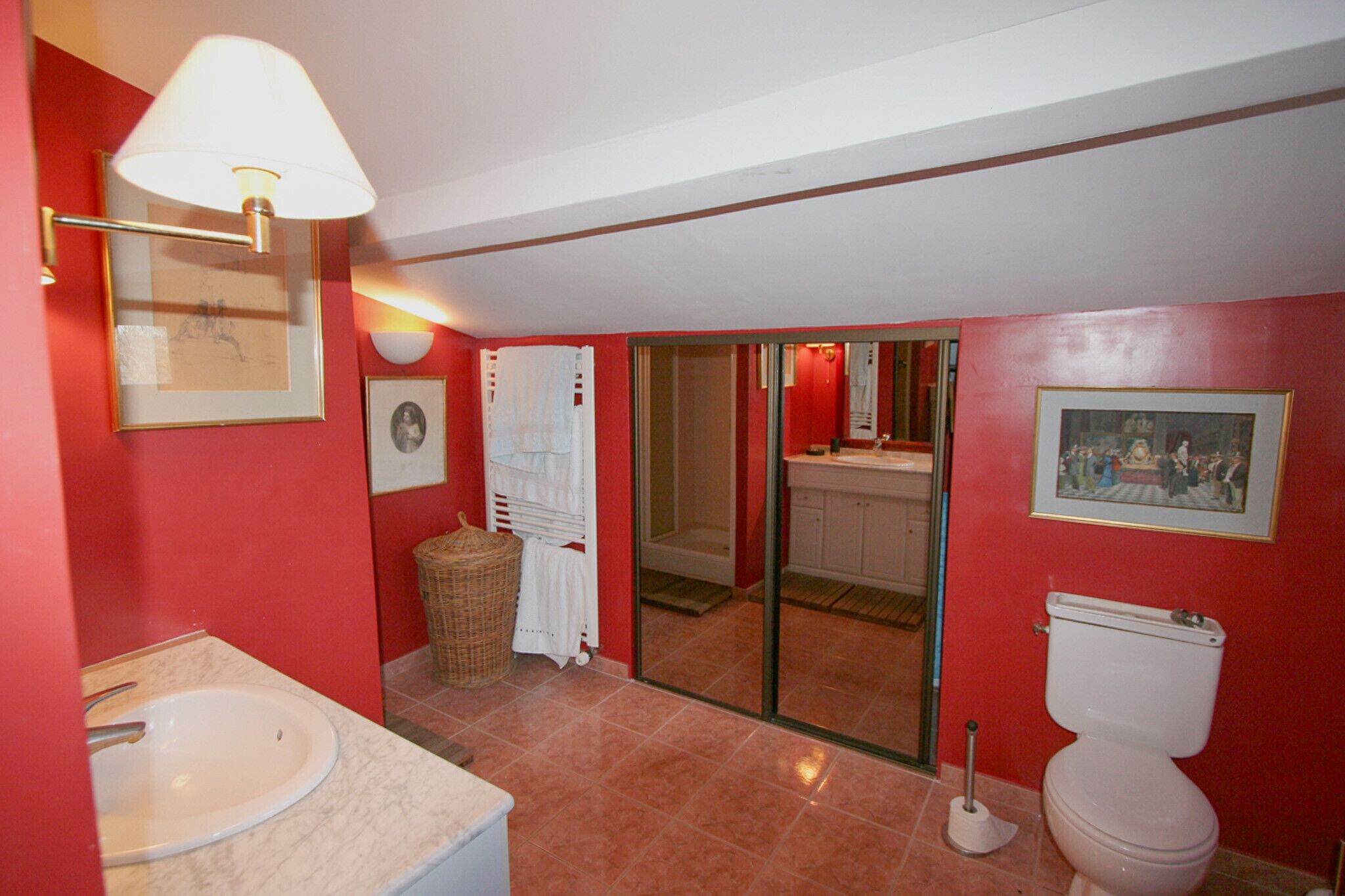 A bathroom with a sink, toilet, and a shower area.