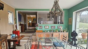 Un comedor con mesa de vidrio, sillas de metal y un tapete rojo estampado.