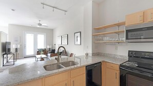 A modern kitchen with granite countertops, stainless steel appliances, and wooden cabinets. - Landing | Amazing 1BD, Clubhouse, Pool (Memphis)