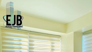 A hotel room with a bed, a bedside table, and a window with blinds. - Mactan Newtown by EJB (Lapu-Lapu City)