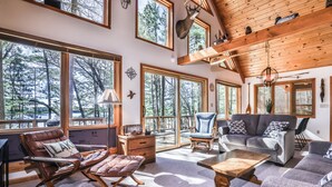 A spacious living room with large windows, a fireplace, and a cozy seating area.